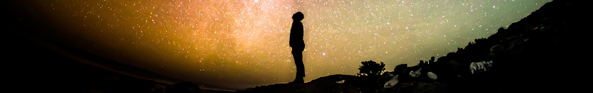 Silhouette of figure in front of planet