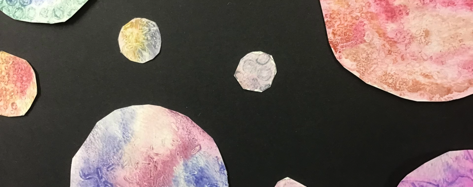 primary child's artwork of the solar system with planets being water coloured