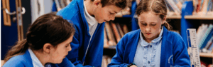 Three primary school pupils working together on a science activity in a classroom